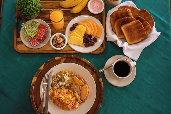 A breakfast tray with various food items including toast, fruit, and a plate of scrambled eggs. - Gamma Durango Plaza Vizcaya (Durango)