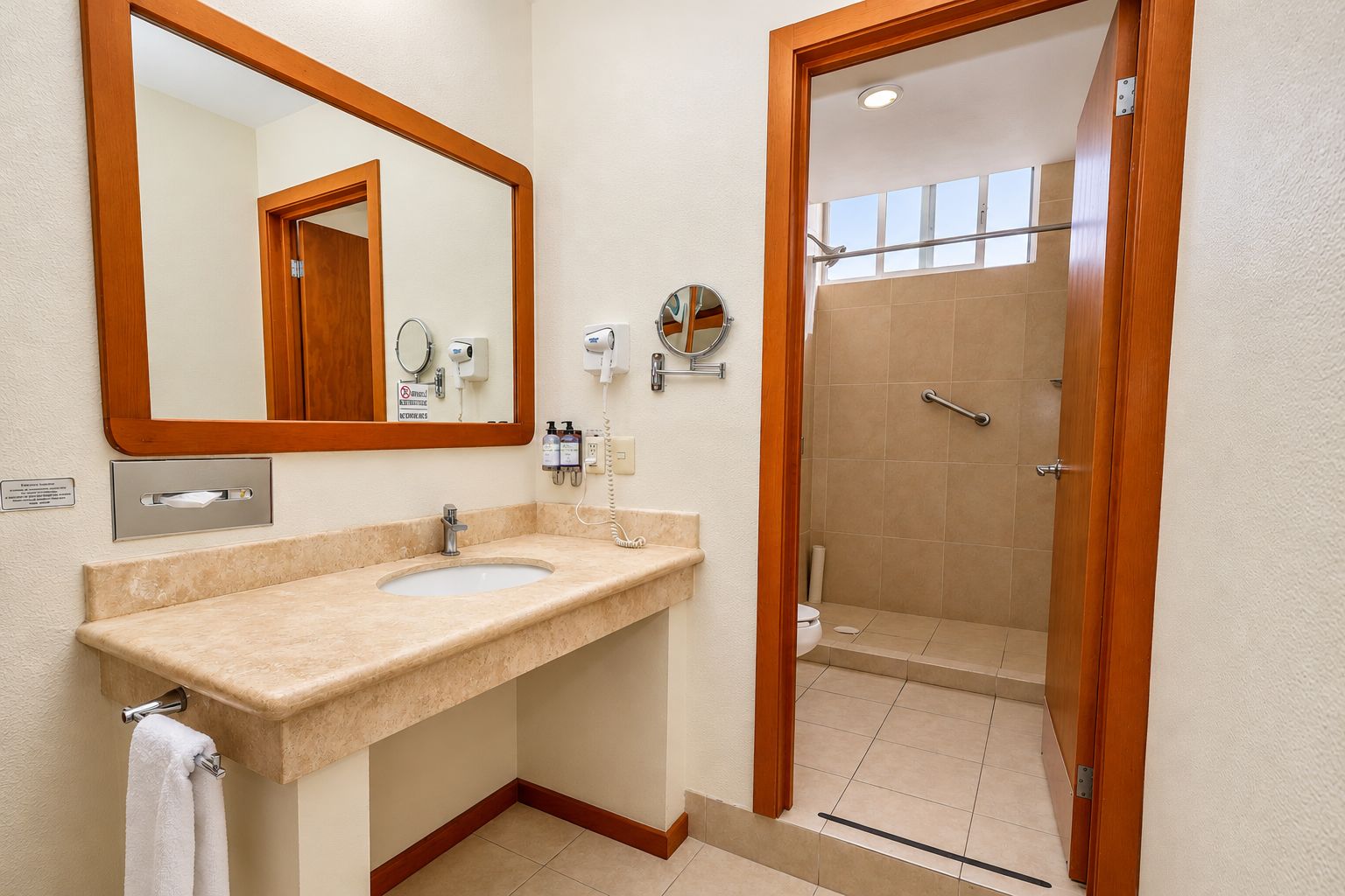 A bathroom with a sink, mirror, and shower.