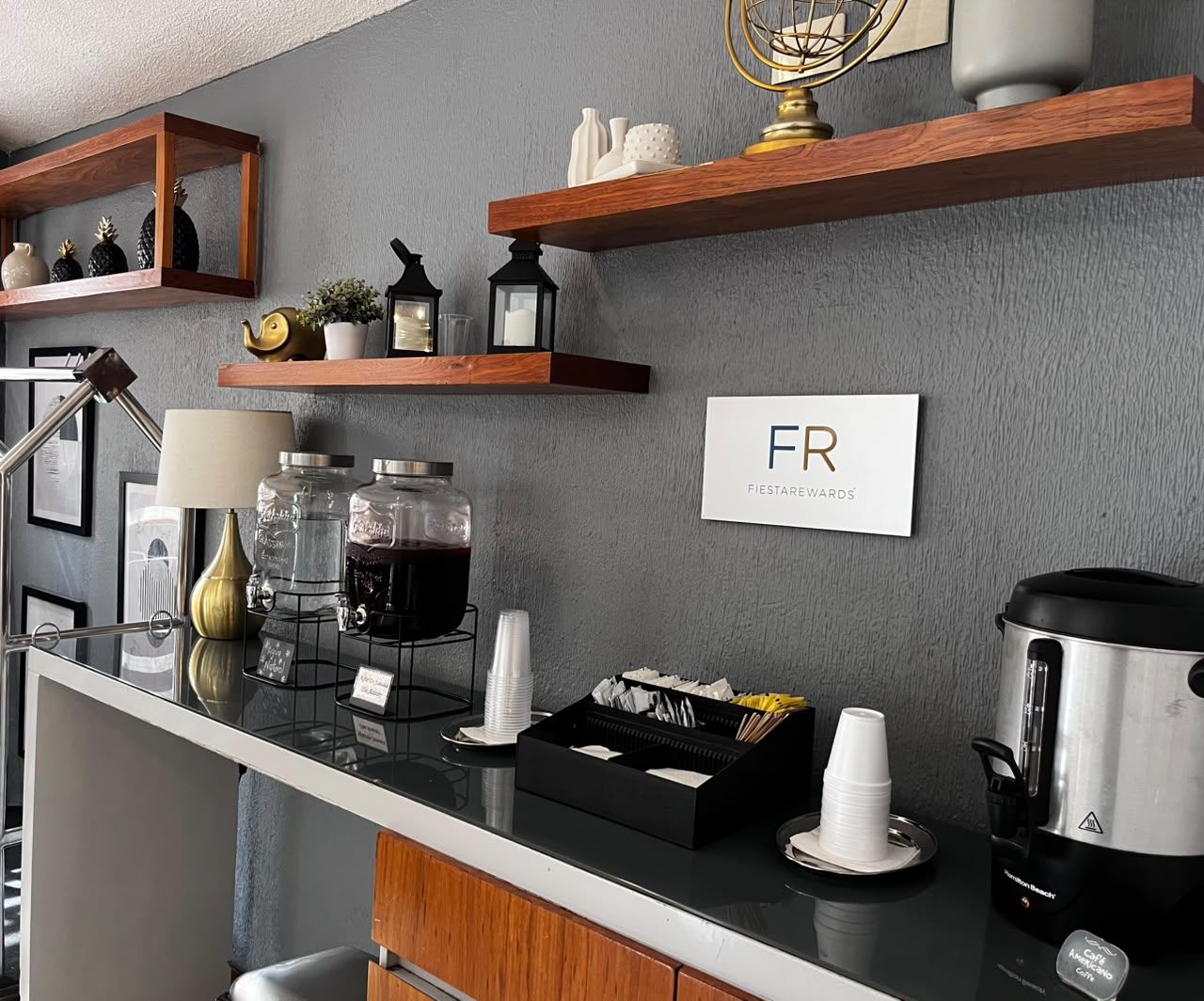 Habitación de hotel con kitchenette, cafetera, tetera y un cartel que indica el tipo de habitación.