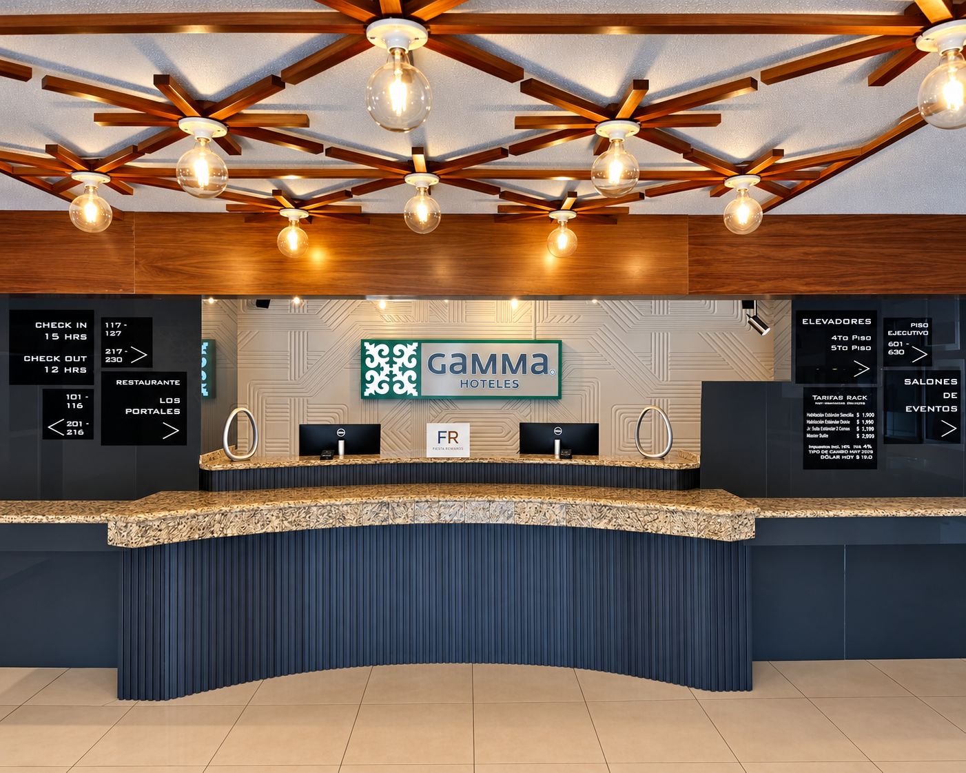 A hotel reception desk with a modern design, including a curved counter, a digital screen, and a ceiling with exposed beams and hanging light fixtures.