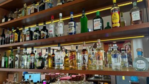 Un bar con varias estanterías llenas de botellas de licor y una gran cantidad de vasos vacíos.