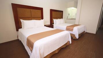 Ein Hotelzimmer mit zwei Betten, Holz-Kopfteilen, weißer Bettwäsche und einem Spiegel über dem Bett.