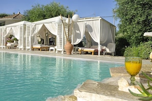 Een buitenzwembad, parasols voor strand/zwembad