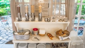 A breakfast buffet setup with various food items and condiments. - Nefeli Hotel (Corfu)