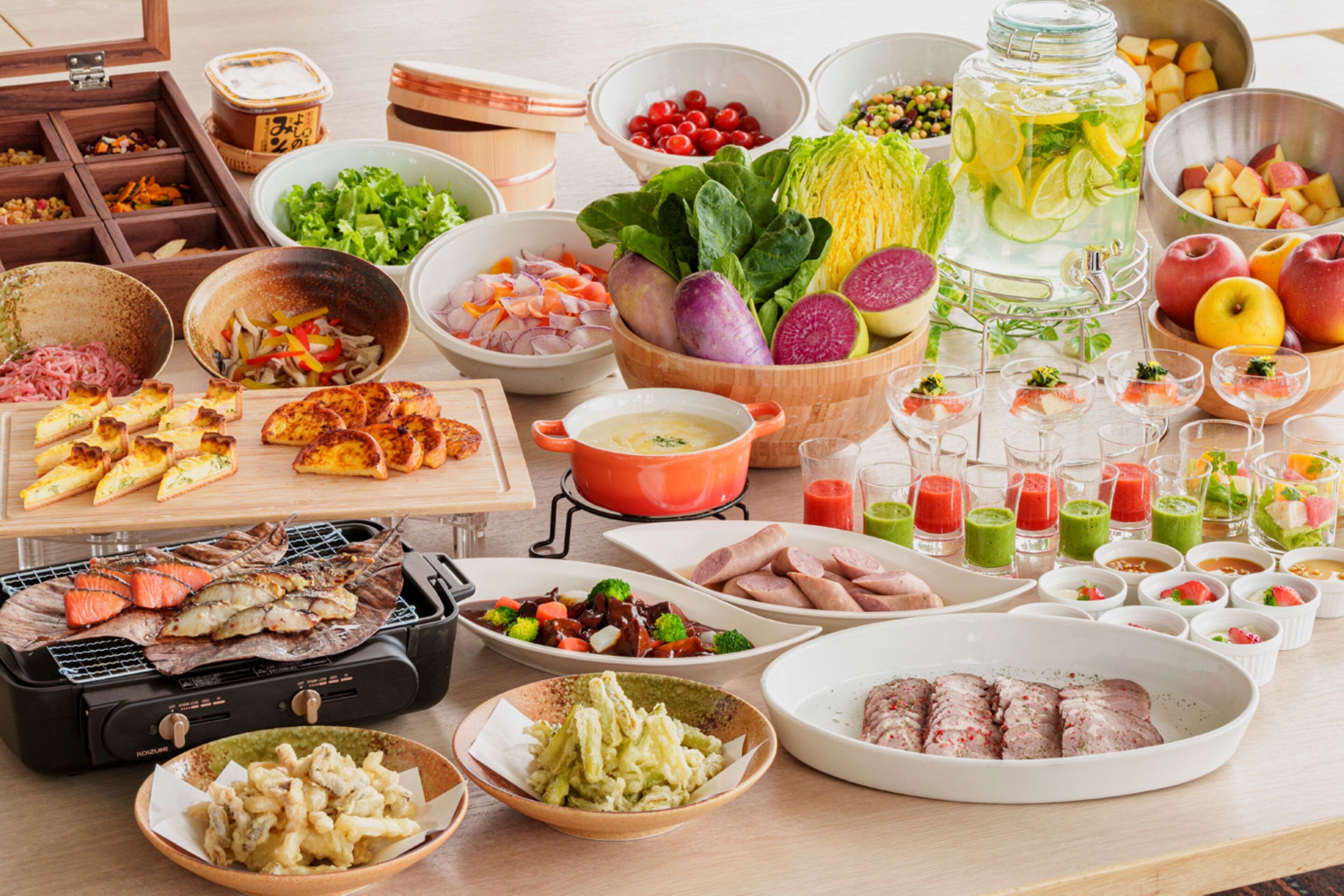 A variety of food items including grilled meat, vegetables, and fruits on a table.