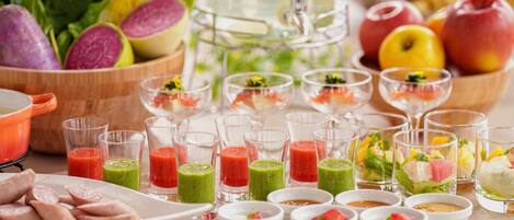Une variété d’aliments et de boissons, notamment des fruits et des légumes frais, ainsi que des boissons servies dans des verres, sont disposés sur une table.