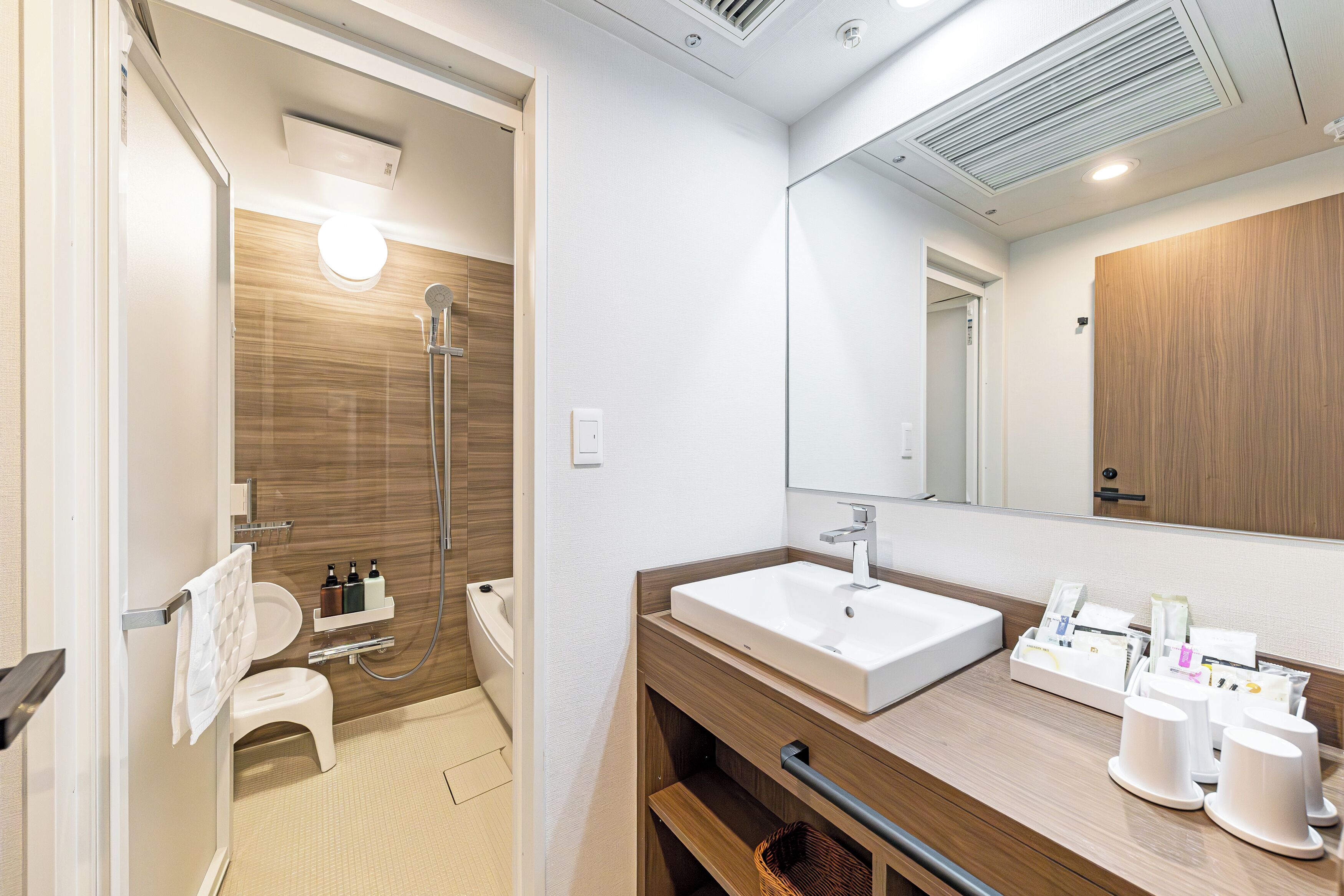 A modern bathroom with a shower, toilet, and sink.