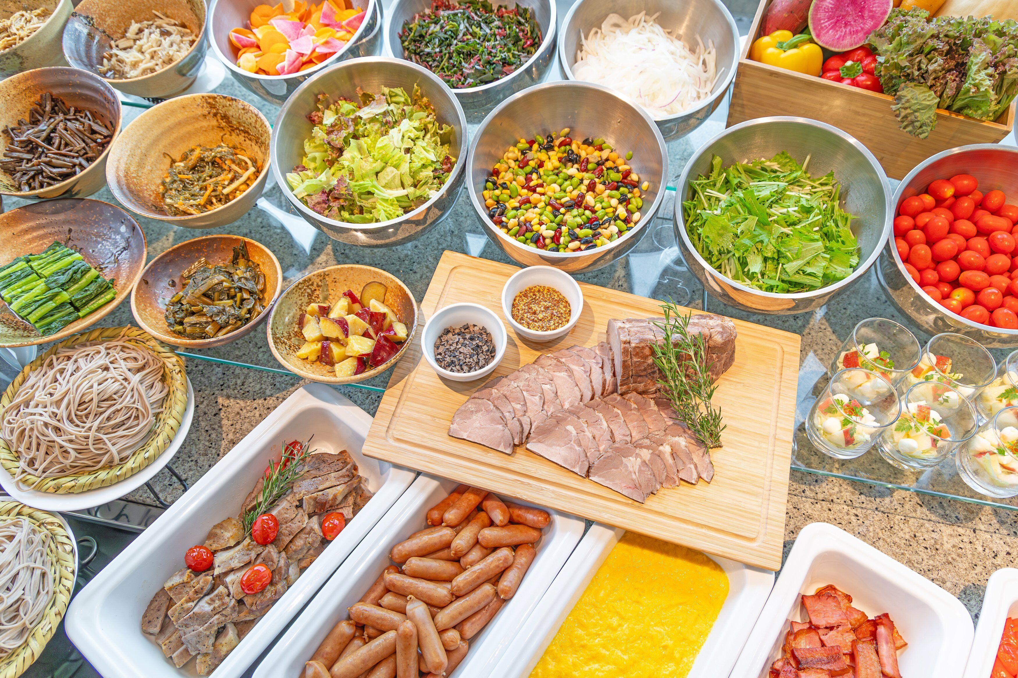 Ein reichhaltiges Buffet mit verschiedenen Gerichten, darunter Fleisch, Gemüse und Salate.