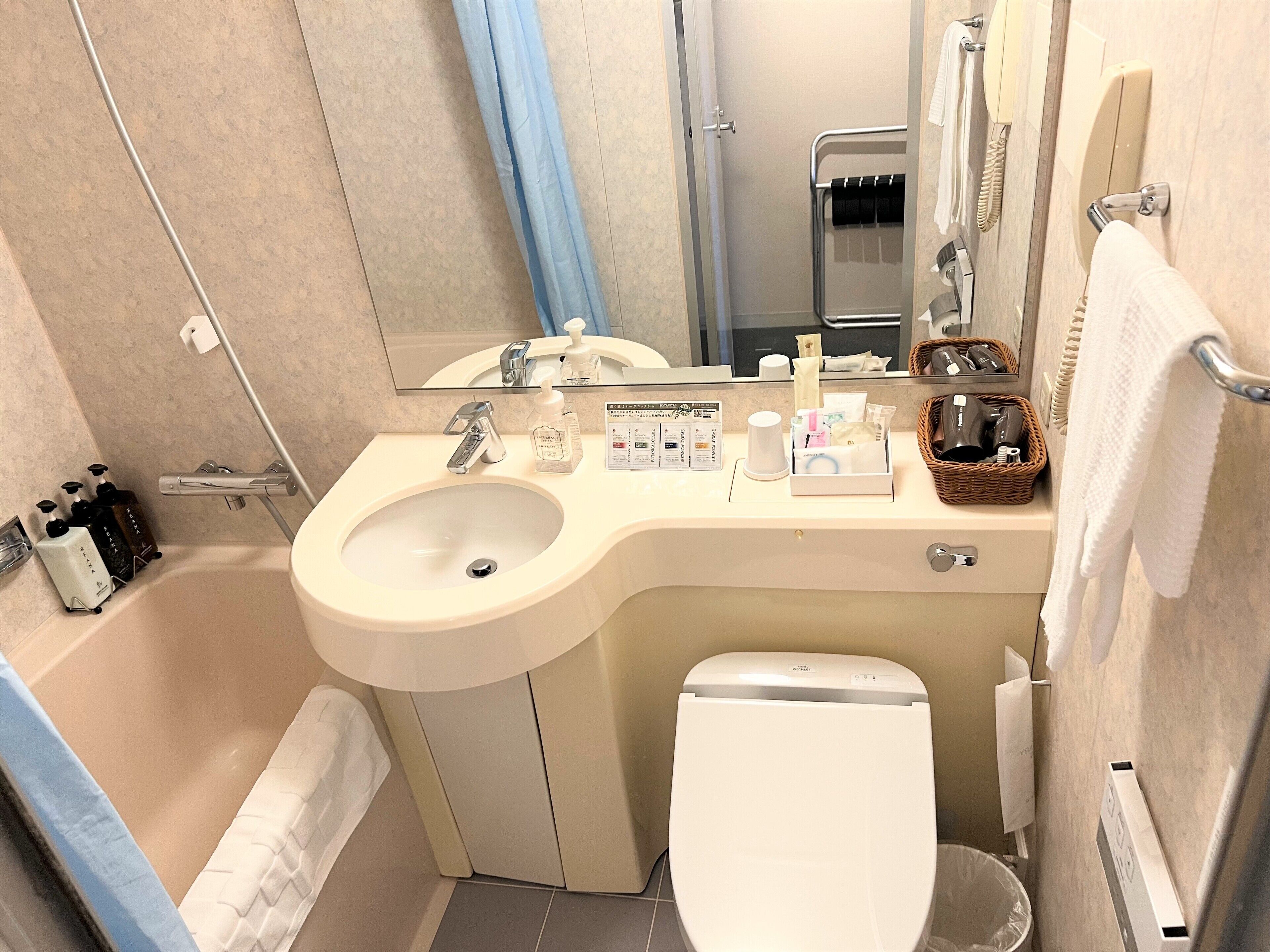 Une salle de bain comprenant un lavabo, des toilettes et un espace douche.