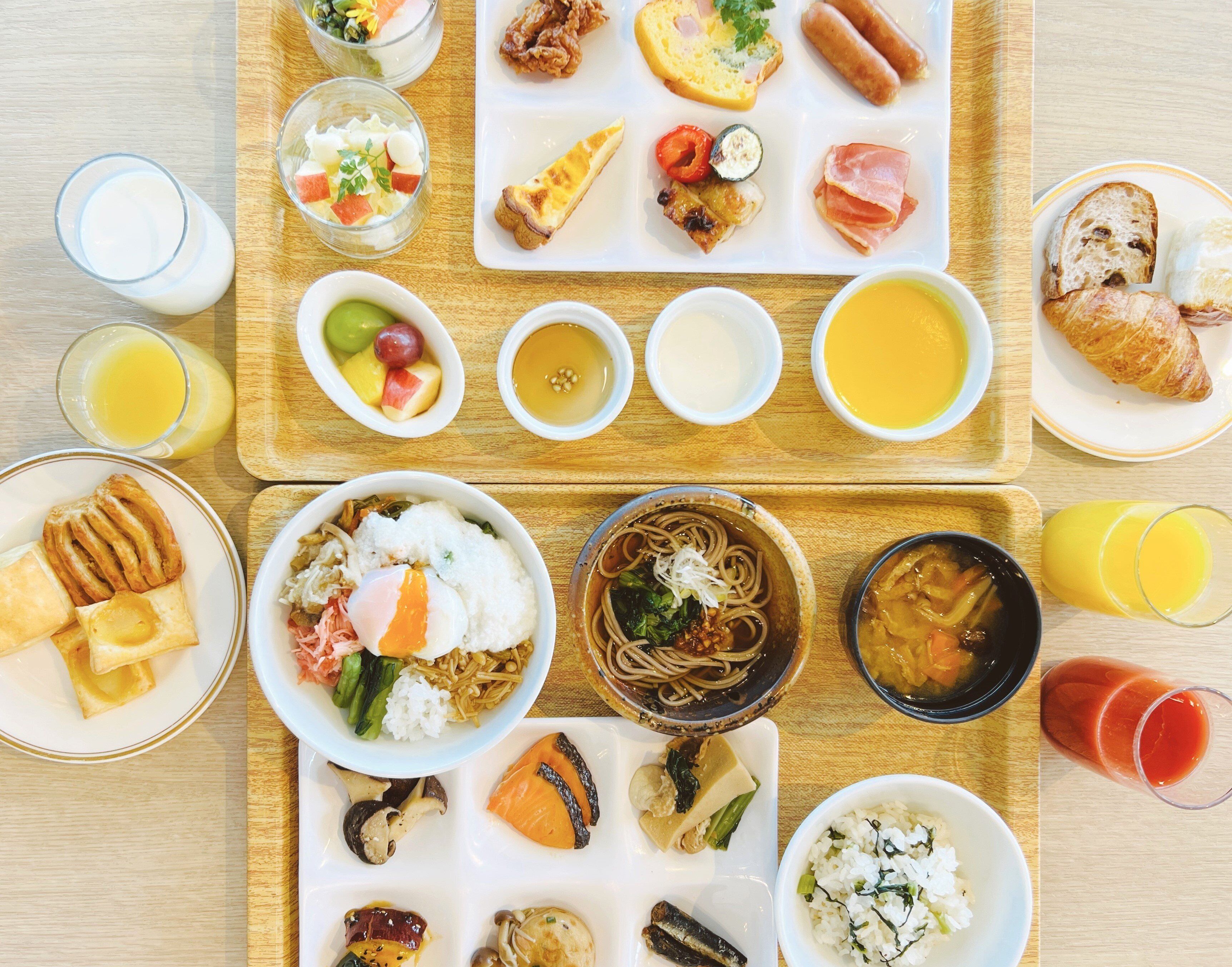 A variety of dishes and drinks on a wooden table, suggesting a meal setting.