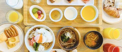 A variety of dishes and drinks on a wooden table, suggesting a meal setting.