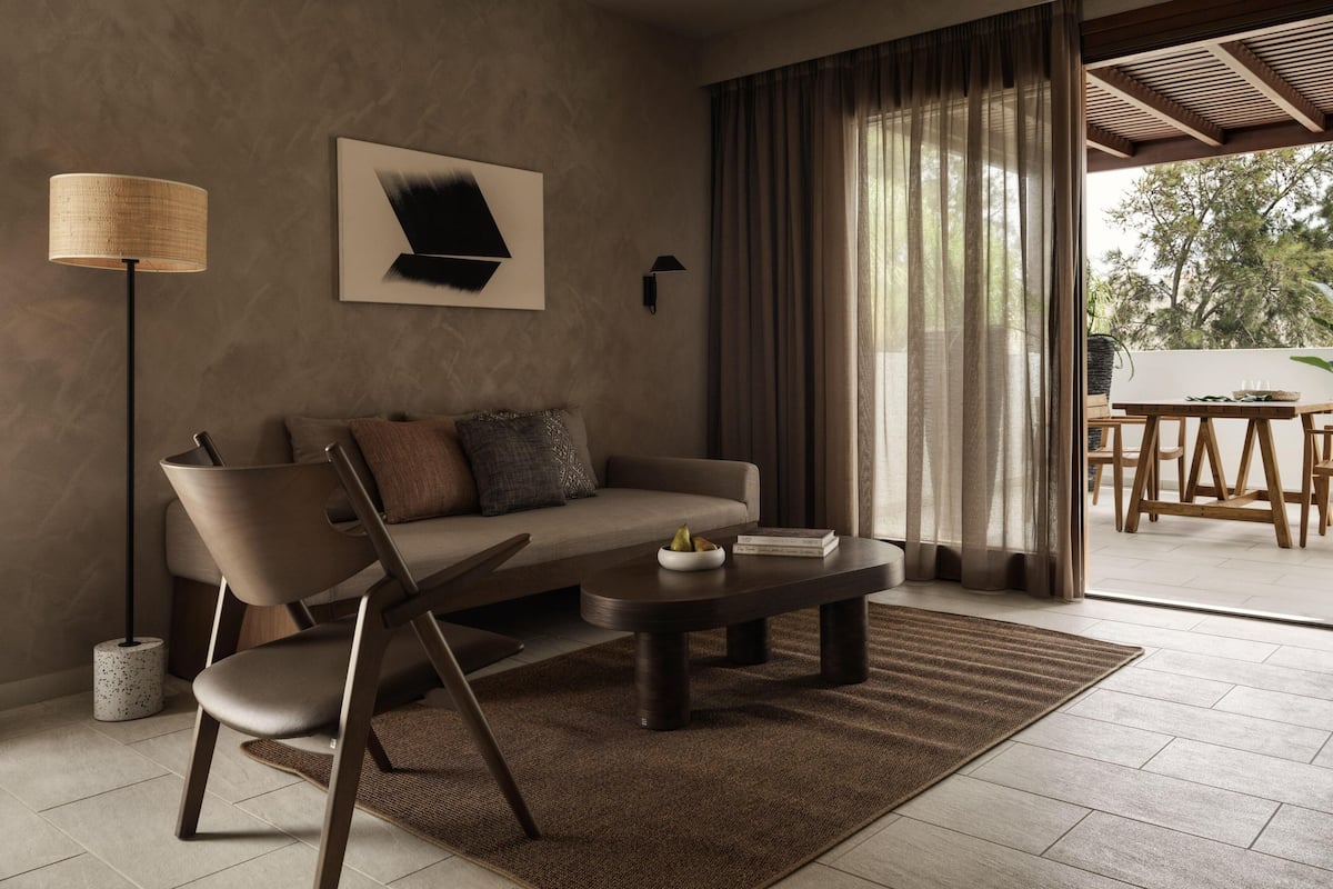 Una sala de estar moderna con un sofá, una mesa de centro y una lámpara de pie.