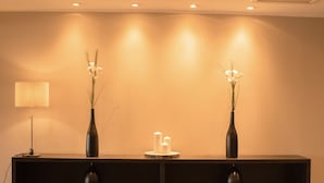 Een plank met drie vazen, een kaars en een lamp.