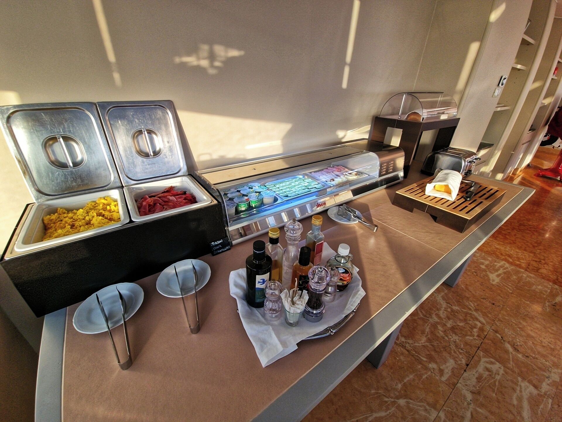 Montaje de bufé con recipientes de comida, una estación de bebidas y un tostador.