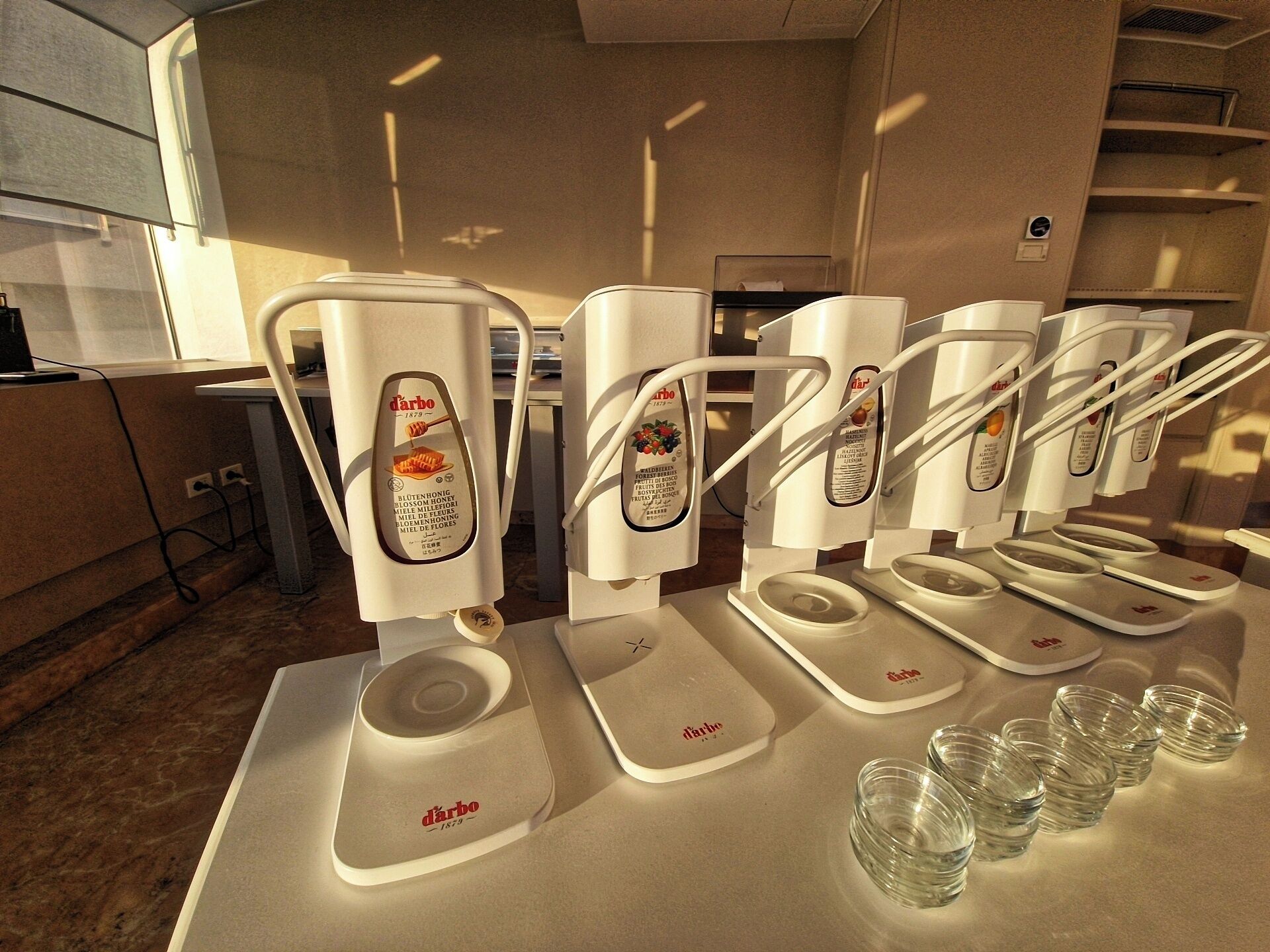 A coffee station with multiple coffee dispensers and disposable cups.