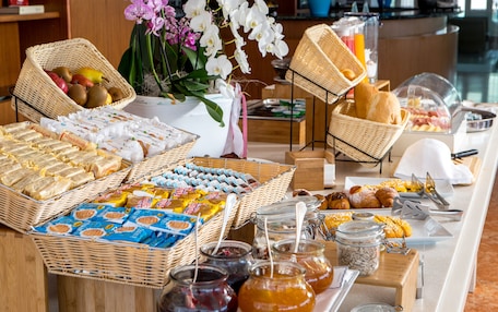 Un bufé con una variedad de alimentos, entre ellos frutas, pasteles y salsas.
