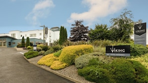 L’entrée d’un hôtel, avec une enseigne indiquant « Viking Hotel Waterford », un espace de stationnement et des jardins aménagés.