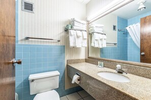 A bathroom with a toilet, sink, and towel rack.