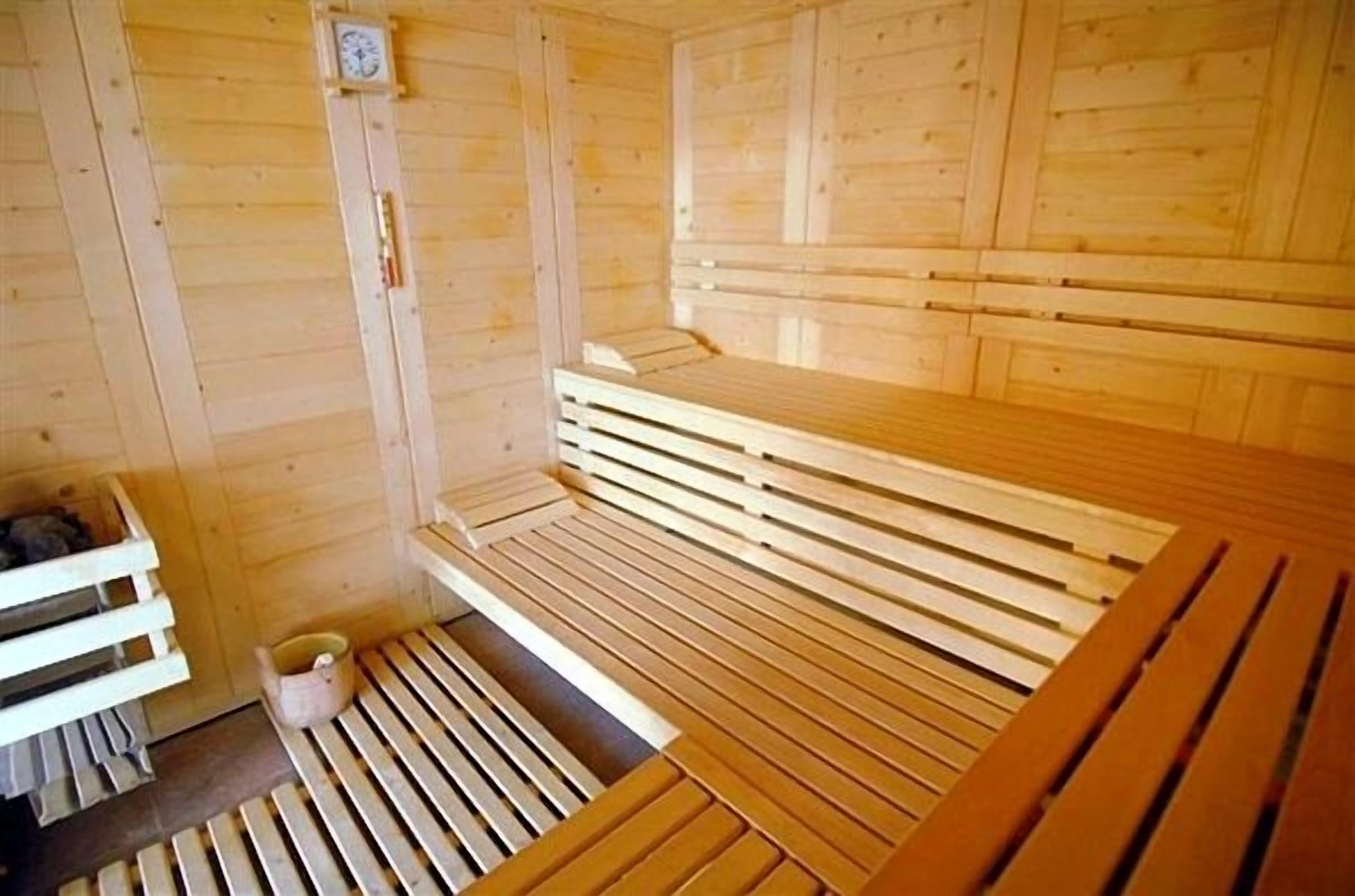 Una sauna con bancos de madera y un pequeño reloj en la pared.