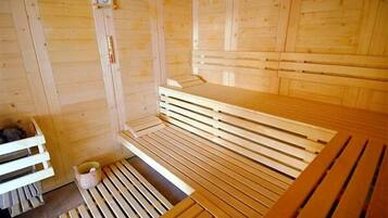 Una sauna con bancos de madera y un pequeño reloj en la pared.