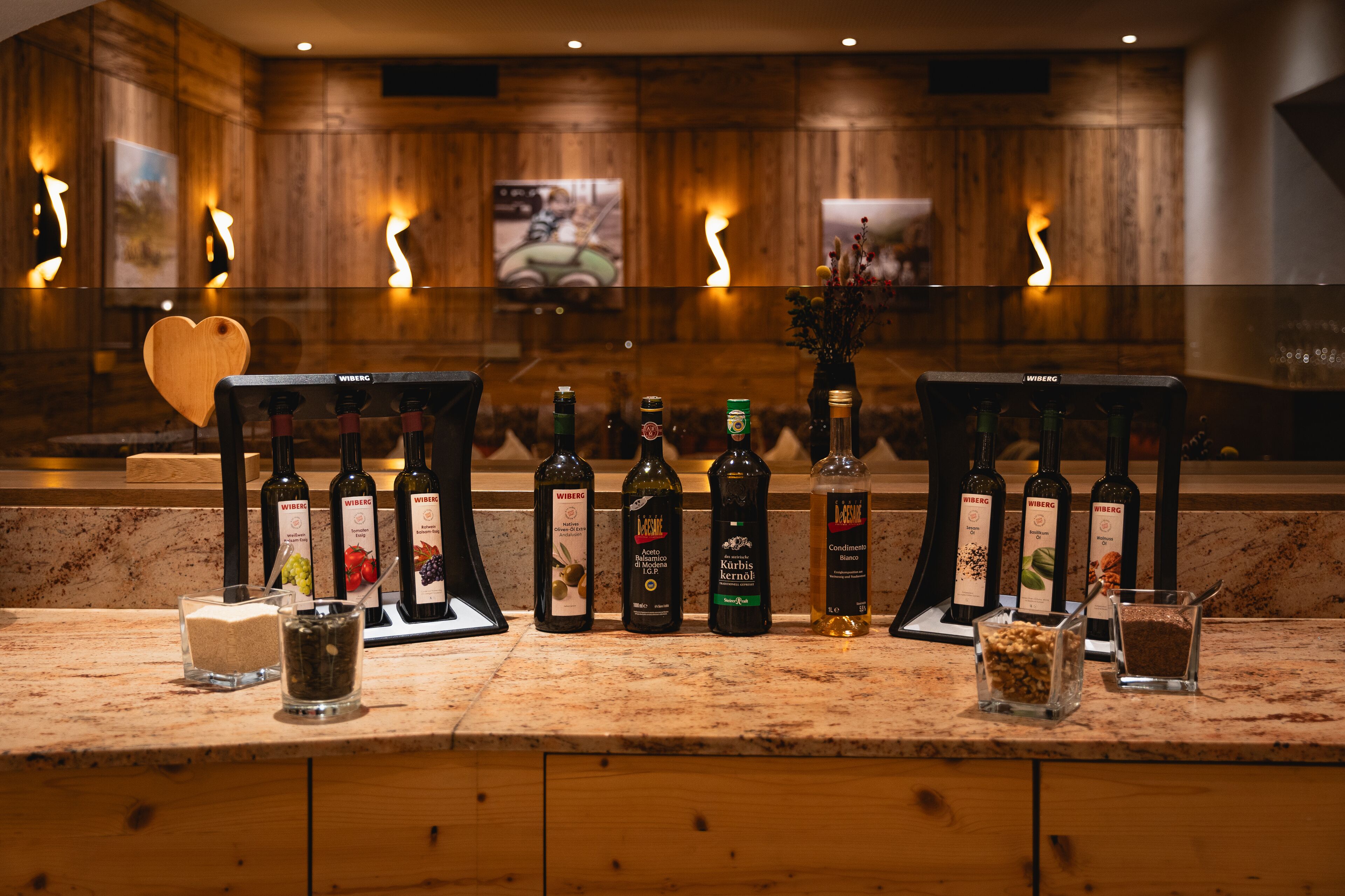 A bar area with wooden paneling, a heart-shaped decoration, and a variety of liquor bottles.