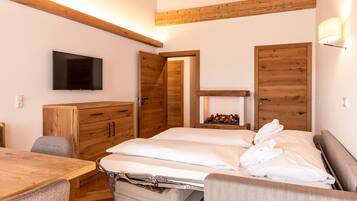 Une chambre à coucher avec un lit, une télévision, des meubles en bois et une cheminée.