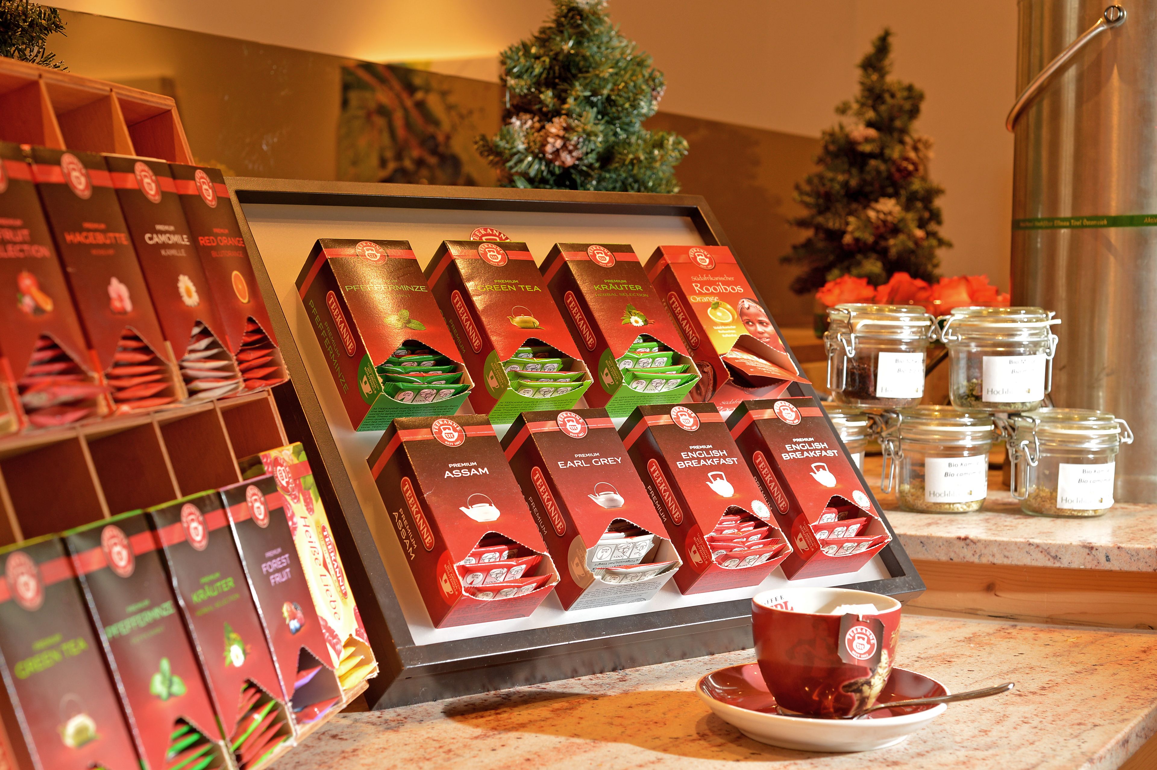 A display of tea boxes and a cup of tea on a counter.