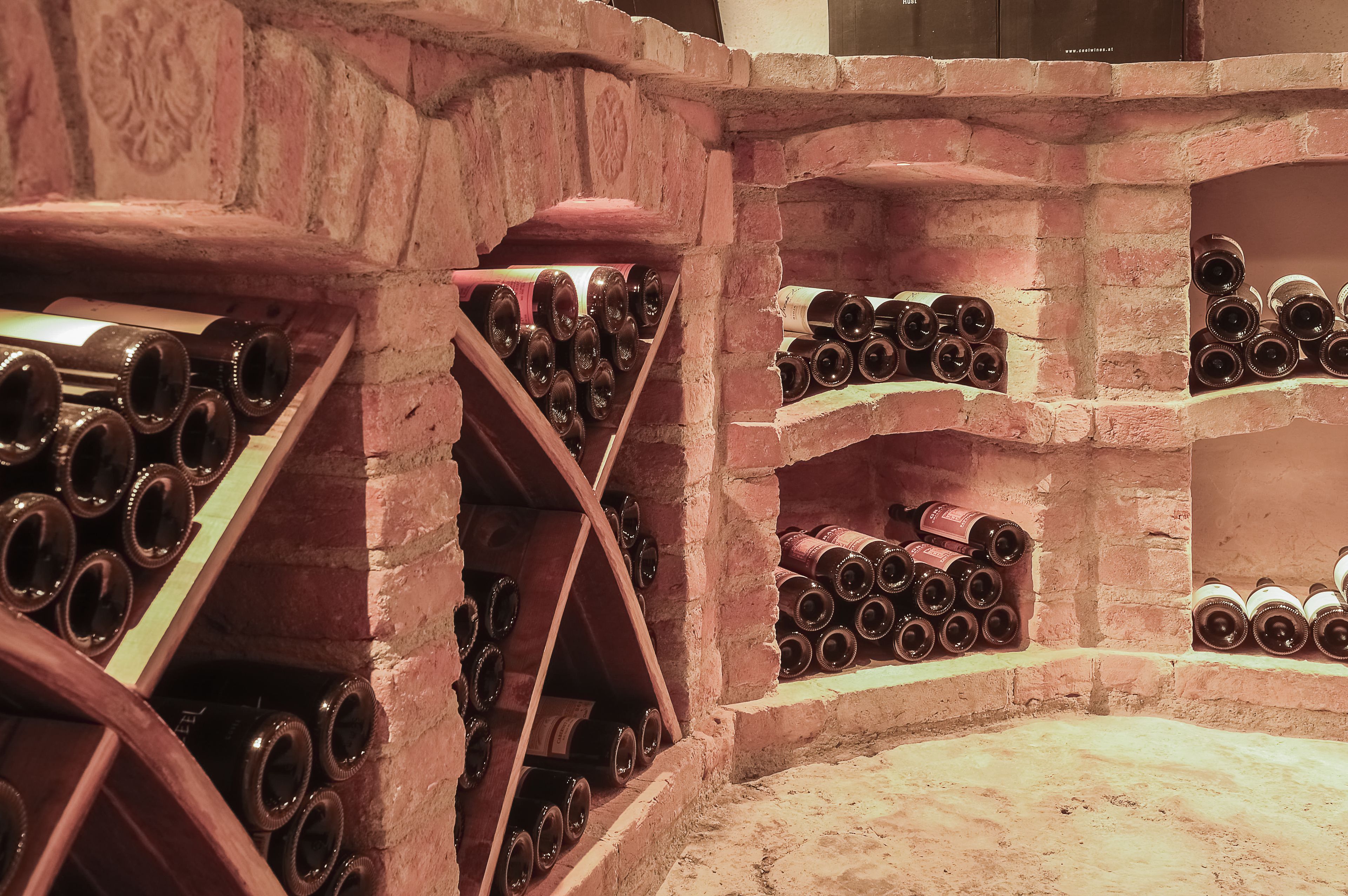 Une cave à vin avec des étagères en bois où sont rangées de nombreuses bouteilles de vin.