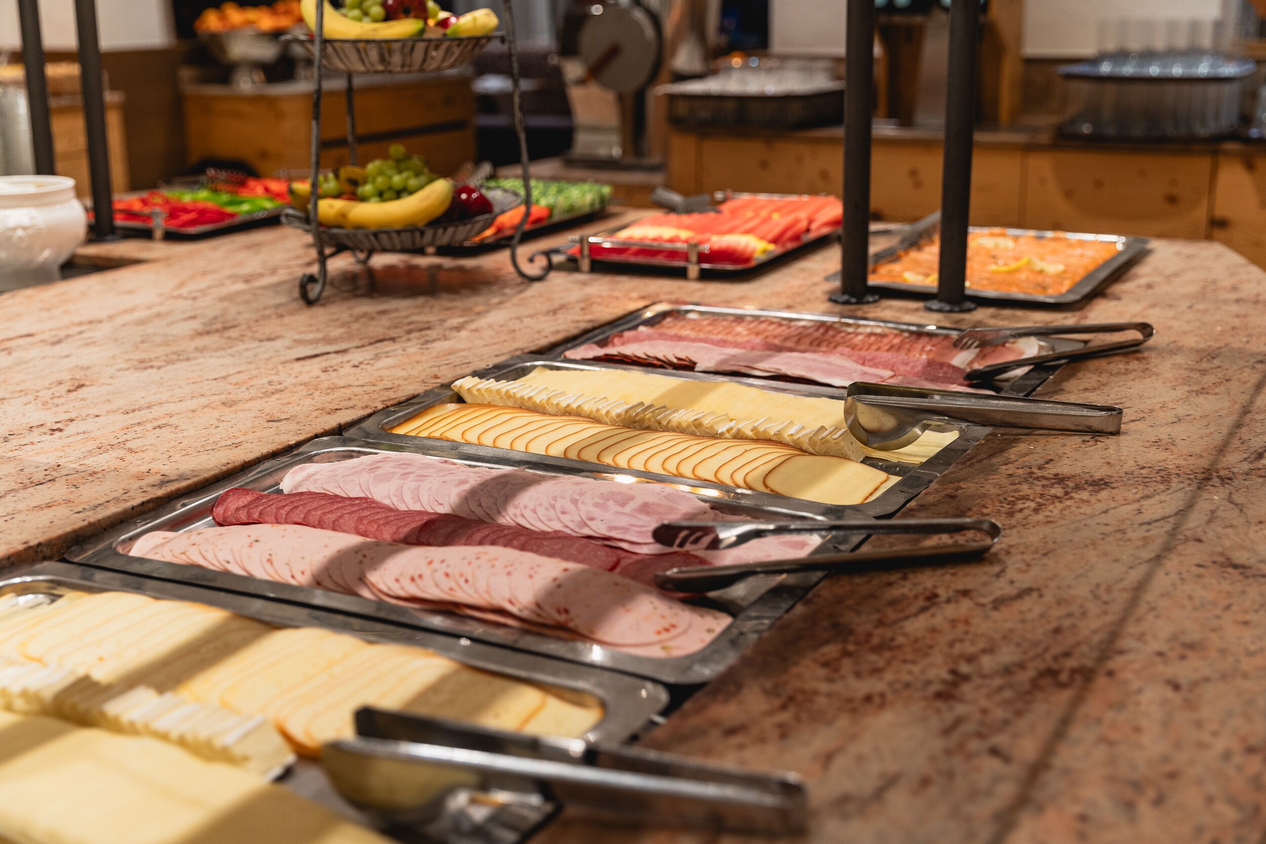 En buffet med forskellige retter, herunder kød og oste.