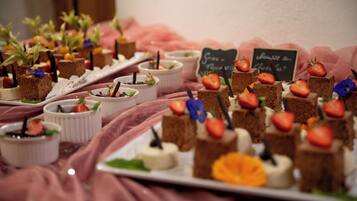 Une table où sont présentés divers desserts, ainsi qu’un panneau noir sur lequel est écrit un message.