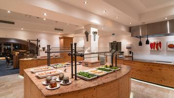 A buffet area with various food stations, wooden counters, and a modern kitchen in the background.