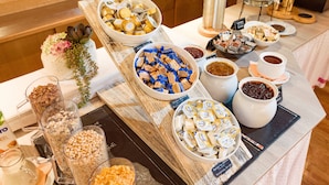 A buffet table with various food items including cereals, chocolates, and spreads. - Hotel Sonnschein (Hopfgarten im Brixental)