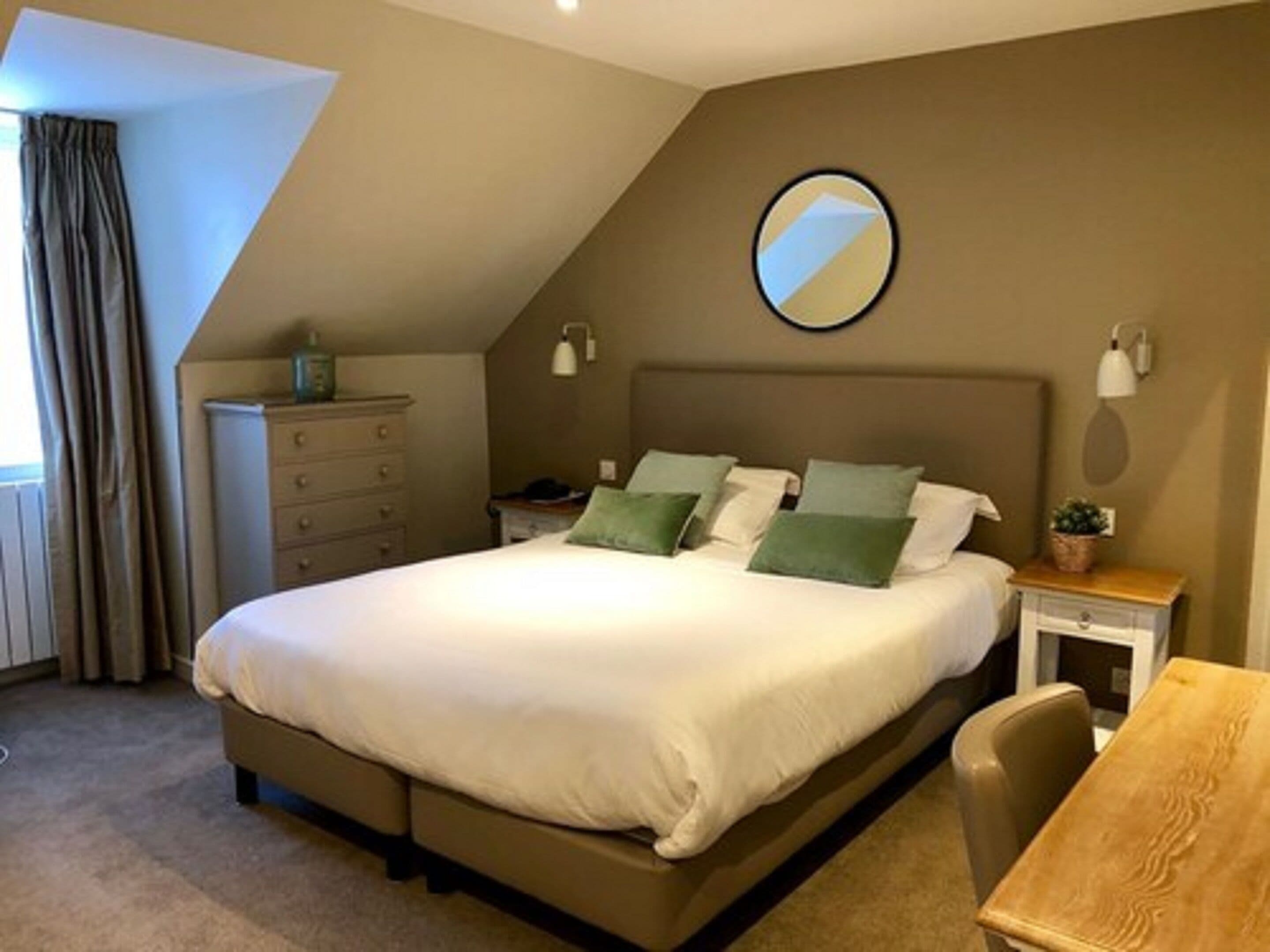 A bedroom with a bed, a dresser, a nightstand, a chair, and a small table.
