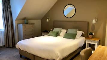A bedroom with a bed, a dresser, a nightstand, a chair, and a small table.