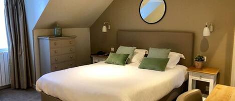 A bedroom with a bed, a dresser, a nightstand, a chair, and a small table.