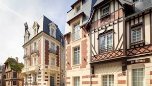 A row of traditional European buildings with distinct architectural styles, including timber framing and brickwork. - Hotel Le Fer à Cheval (Trouville-sur-Mer)