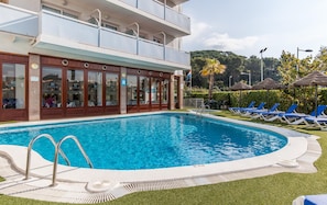 A hotel with a pool area, including a swimming pool, lounge chairs, and a building with multiple floors. - BLUESEA Montevista Hawai (Lloret de Mar)