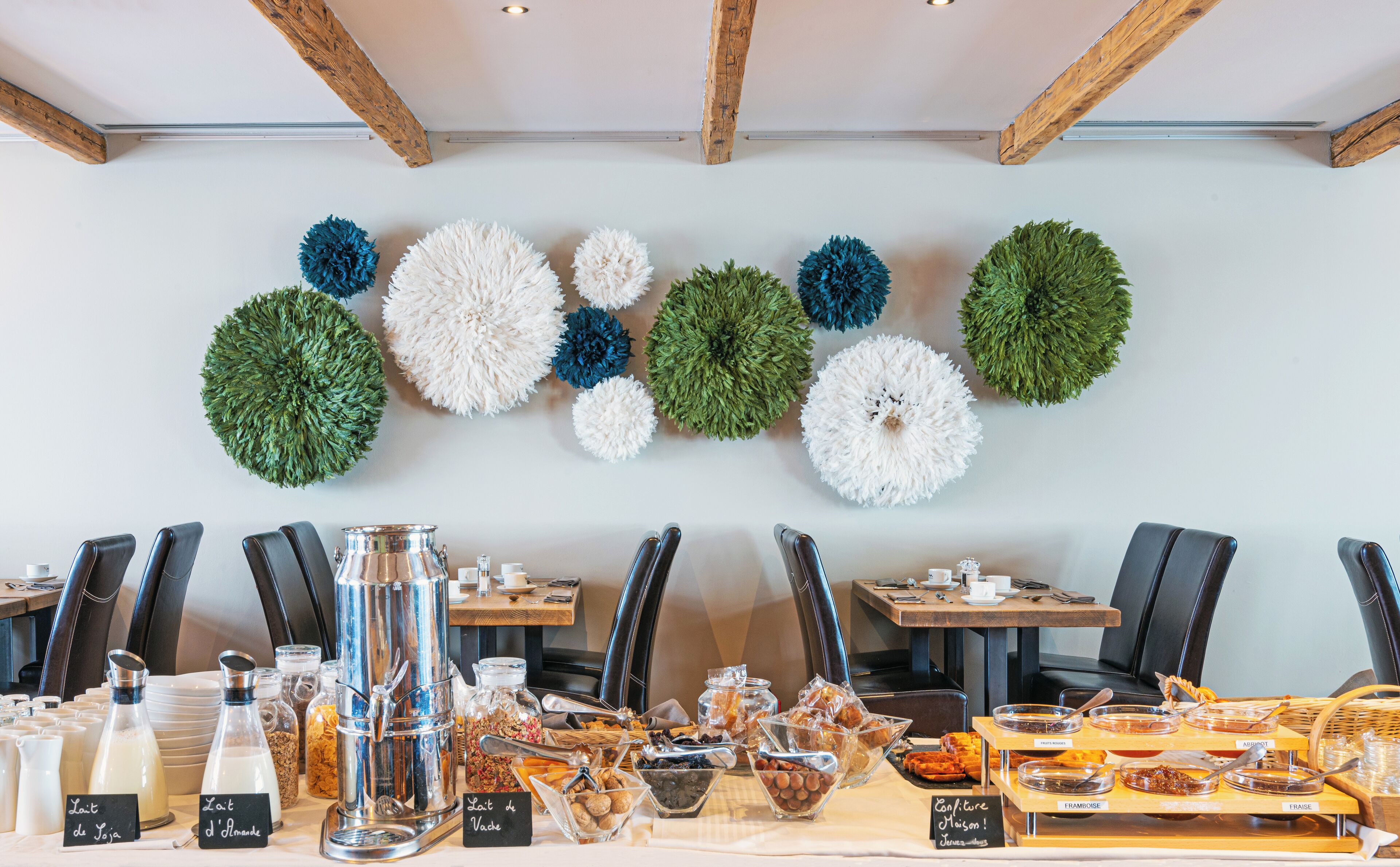 Ein Frühstücksbuffet mit verschiedenen Speisen und einer Wand, die mit kugelförmigen Verzierungen geschmückt ist.