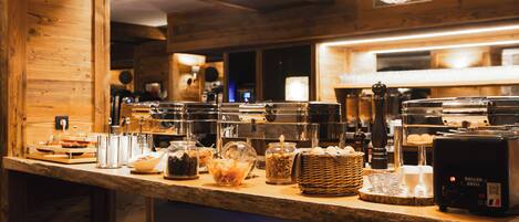 Un mostrador de buffet con distintos alimentos y una máquina de café.