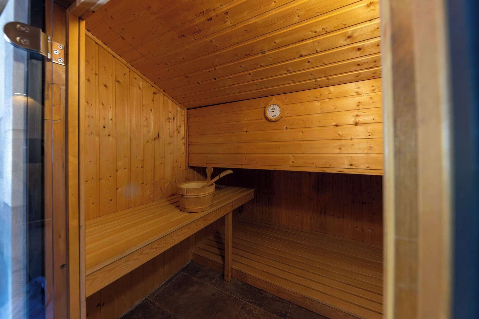 A sauna room with wooden walls and a bench.