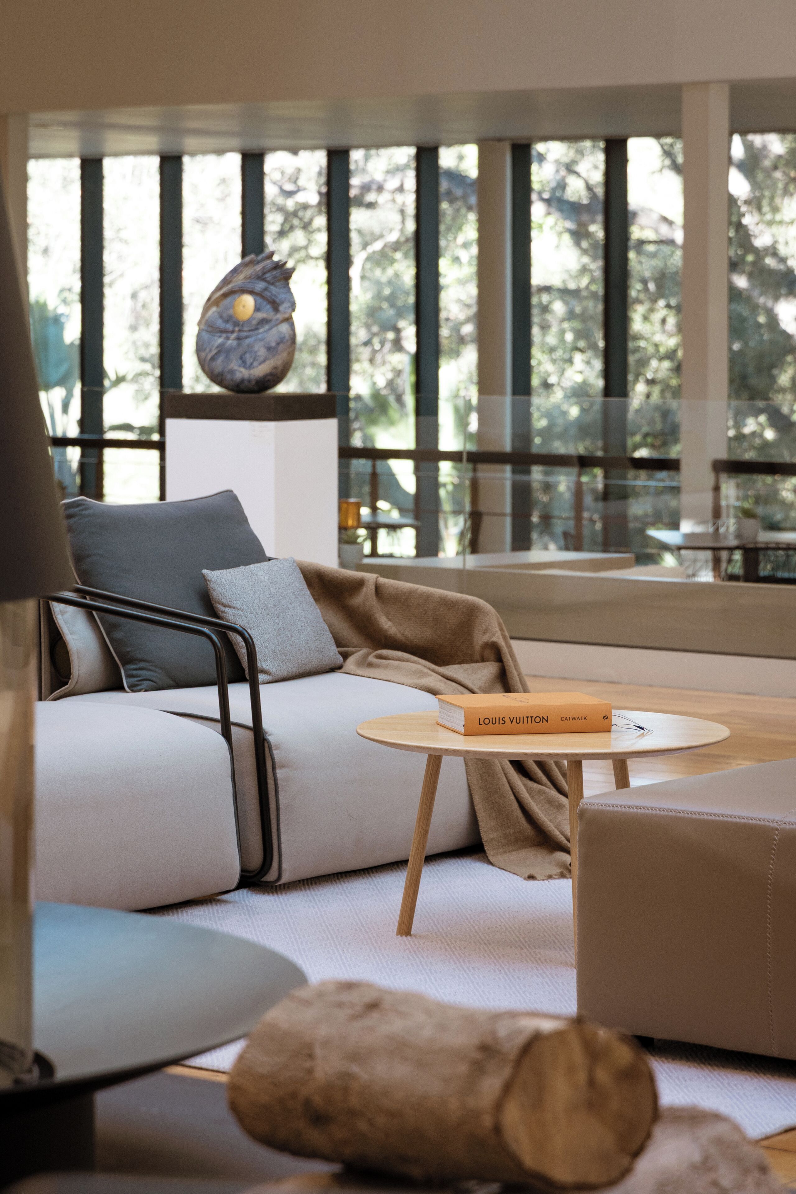 Una sala de estar moderna con un sofá, una mesa de centro y un libro titulado "Louis Vuitton".