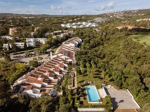 A resort with multiple white buildings, a swimming pool, and lush greenery. - Hotel Encinar de Sotogrande (San Roque)