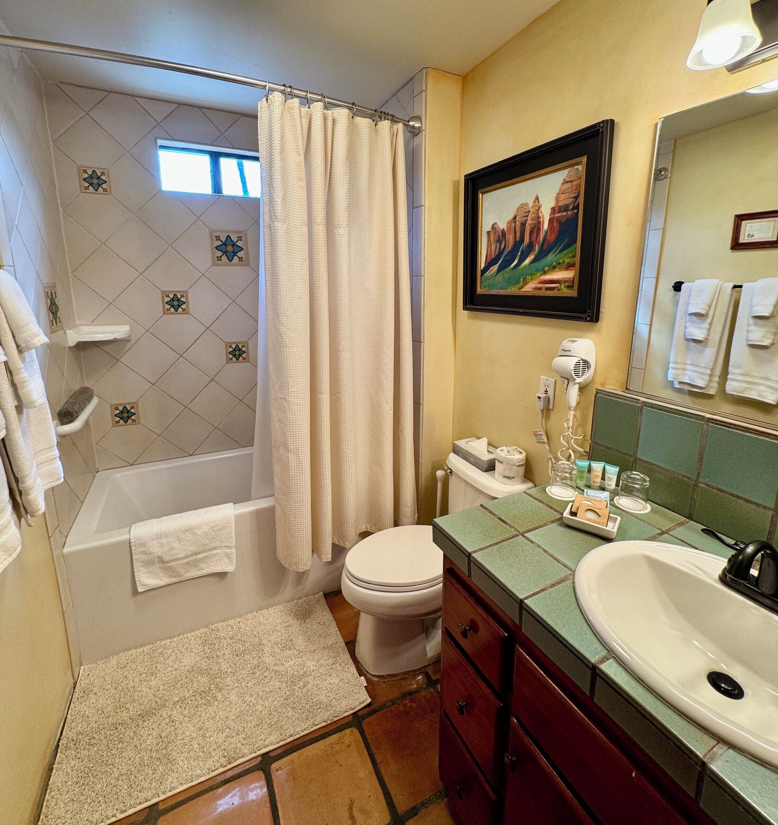 Un baño con bañera, inodoro, lavabo y cortina de ducha.