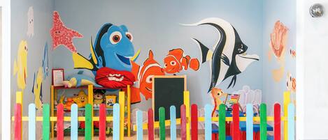 A children's play area with colorful decorations and a mural of sea creatures.