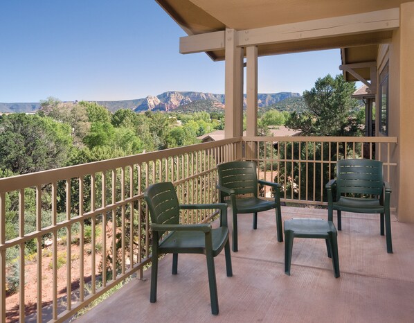 A balcony with a view of mountains and trees. There are four green chairs and a small table. - Club Wyndham Sedona (Sedona)