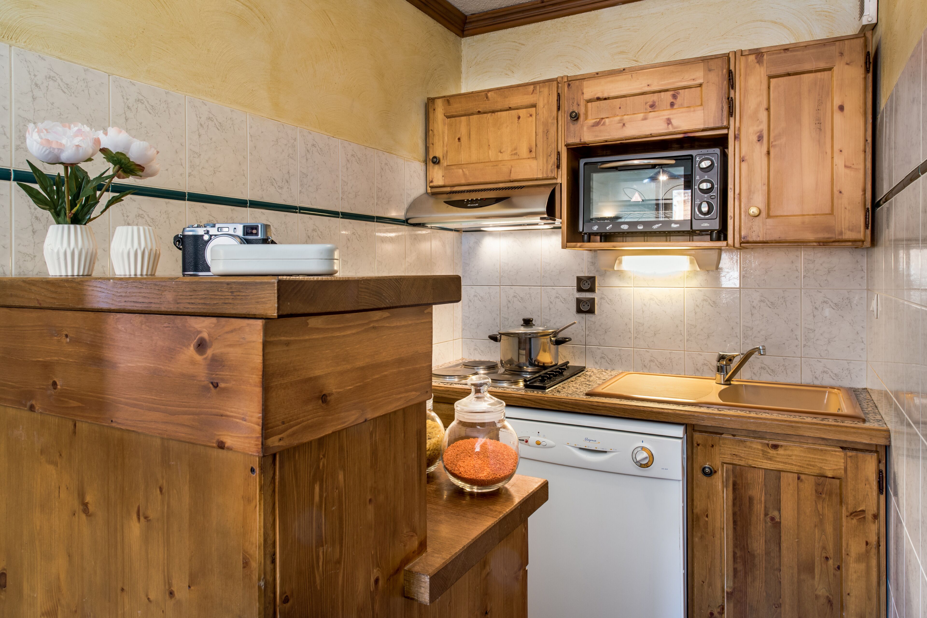 A kitchen with wooden cabinets, a microwave, a stove, and a dishwasher.