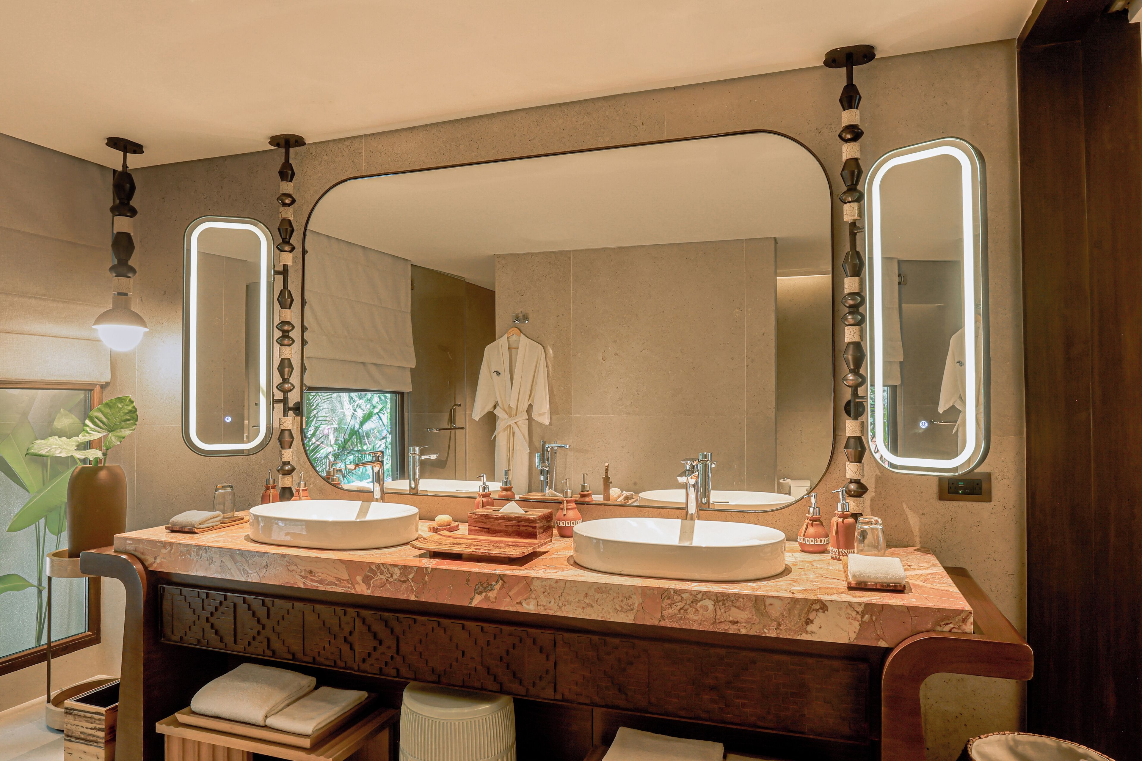 A modern bathroom with two sinks, a large mirror, and a towel rack.