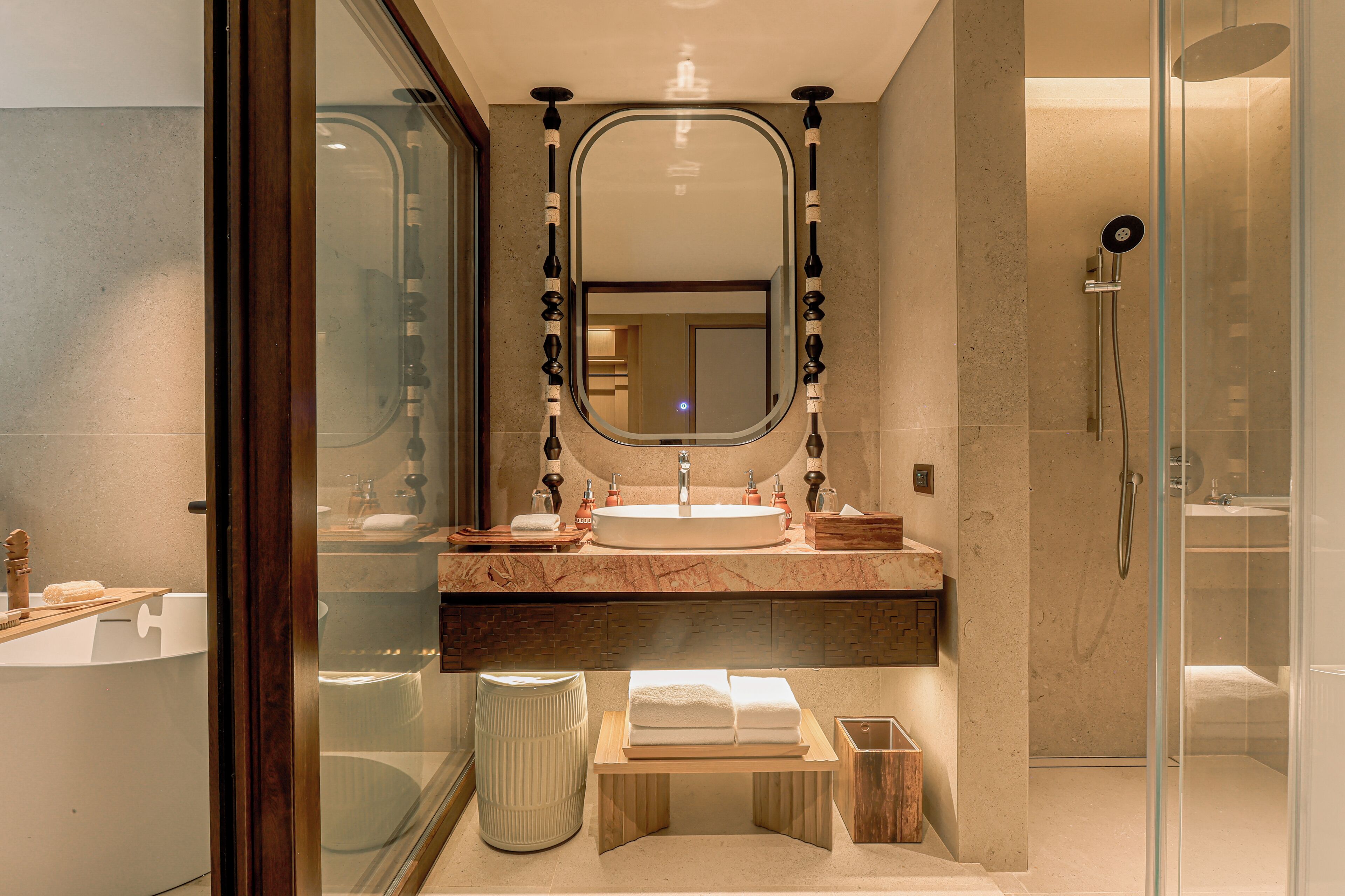 Un bagno moderno con uno specchio grande, un lavandino rotondo e una cabina doccia in vetro.
