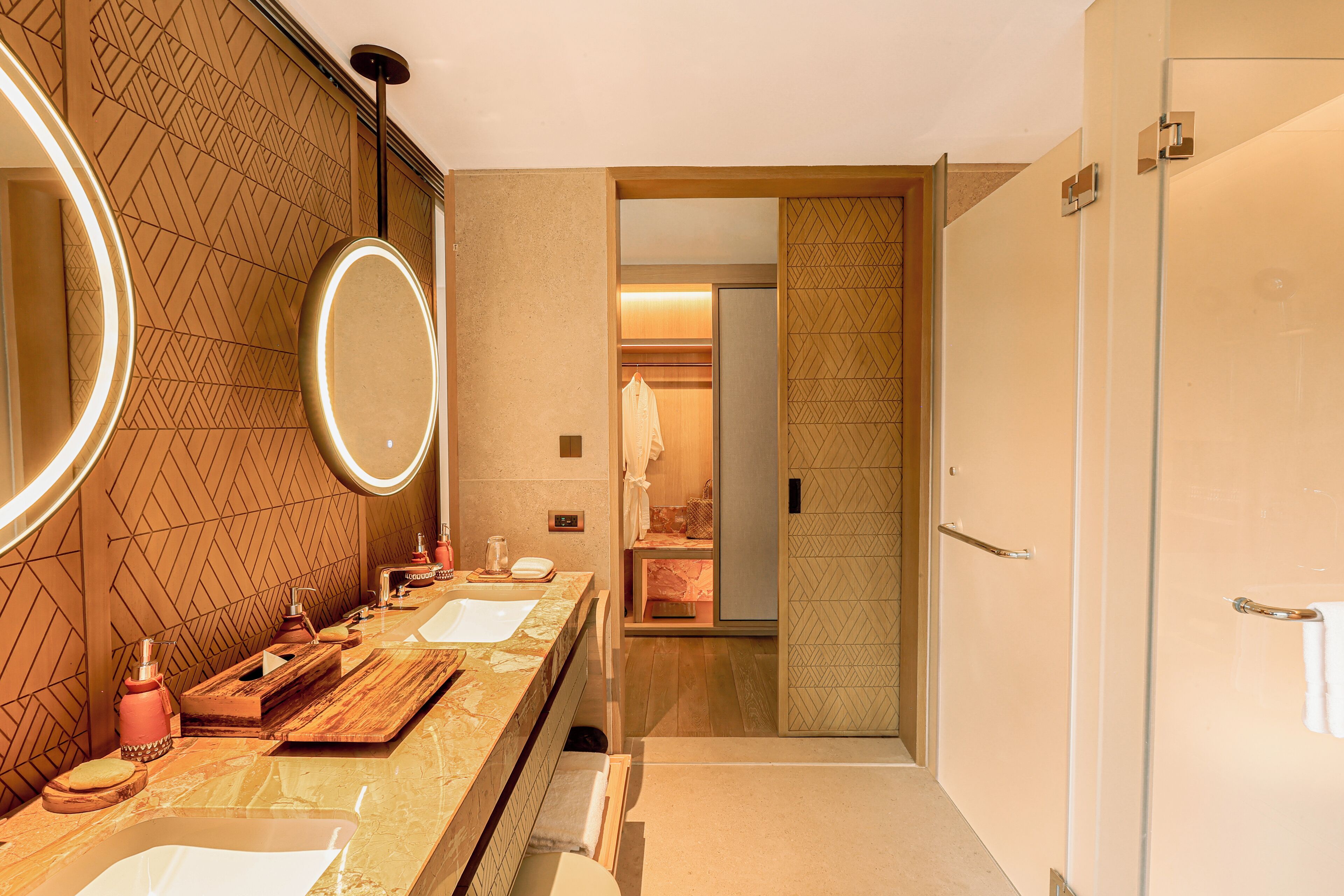 Une salle de bain moderne avec un meuble-lavabo, deux vasques, un miroir et un espace douche.