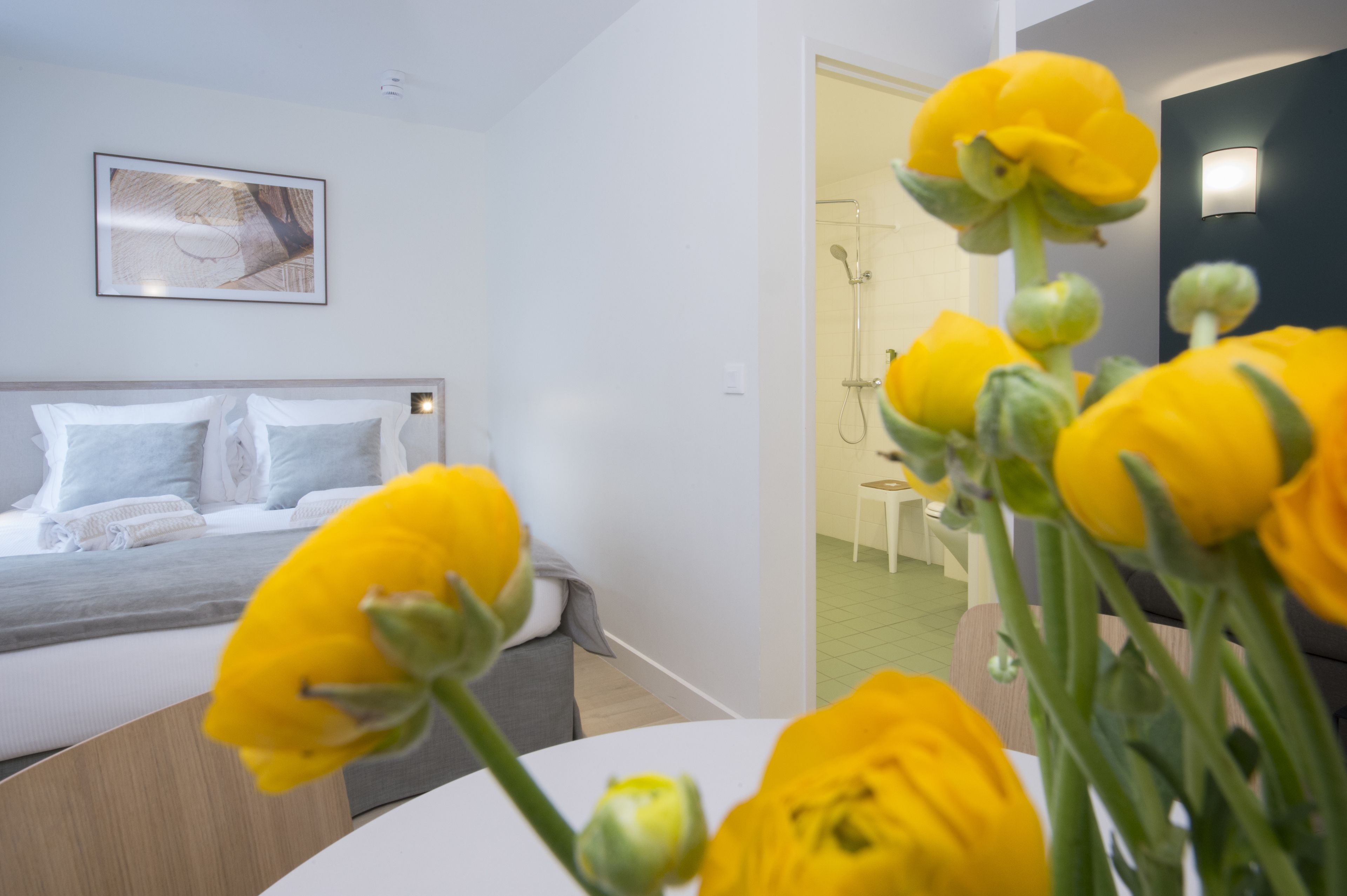 Ein modernes Schlafzimmer mit einem Bett, einem Nachttisch und einem Wandbild.